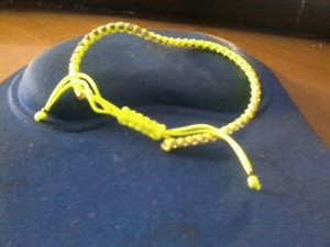 Pulsera amarilla con brillantes de hilos.